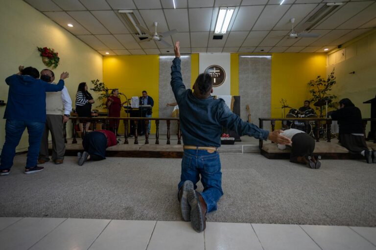 A spiritual gathering with people praying and worshiping in a temple in Ciudad Juárez.